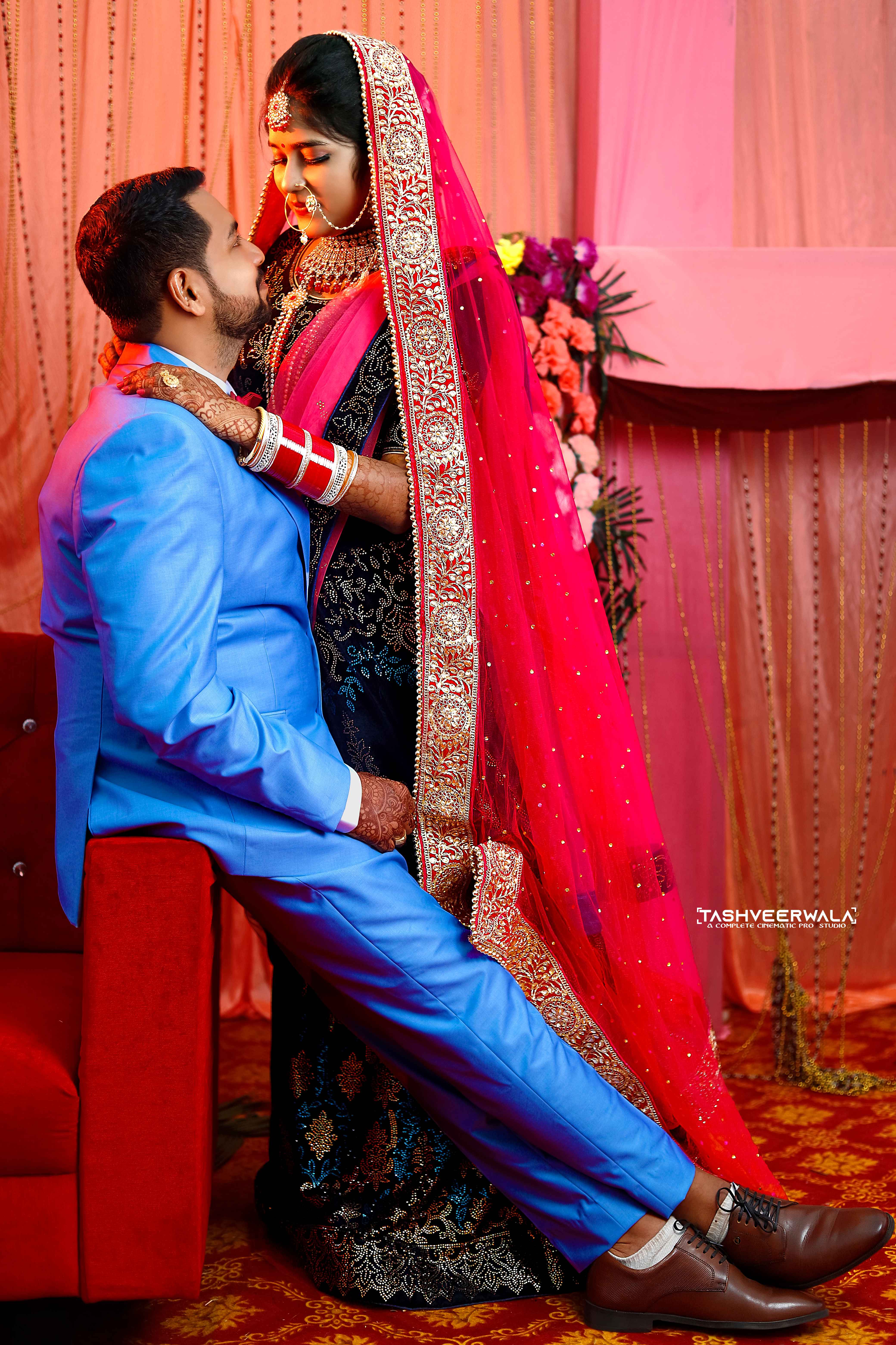 Intimate wedding ritual moment with couple in traditional blue and red attire