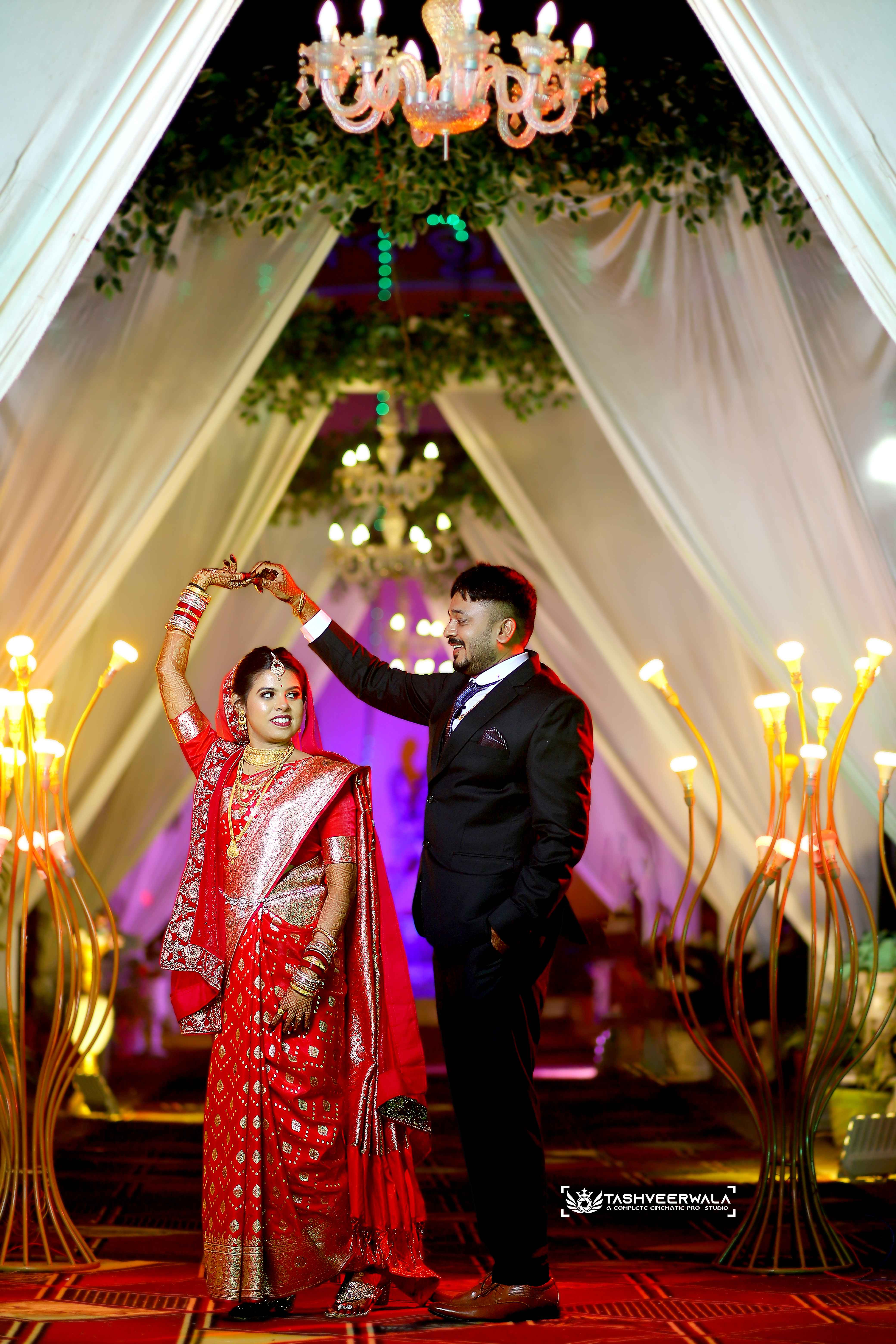 Elegant reception moment under chandeliers with luxurious venue decoration